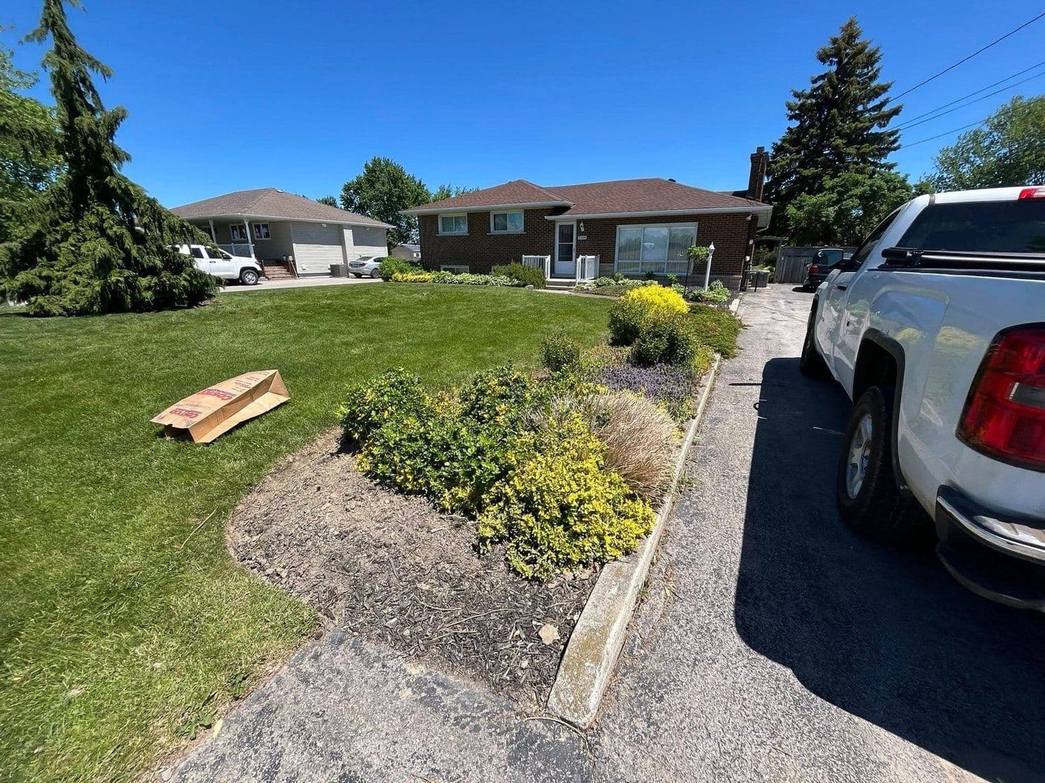 Landscaped front yard with a new garden bed beside the driveway